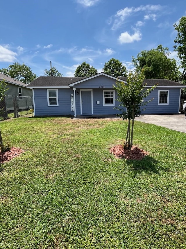 ranch-style home featuring a front lawn and fence