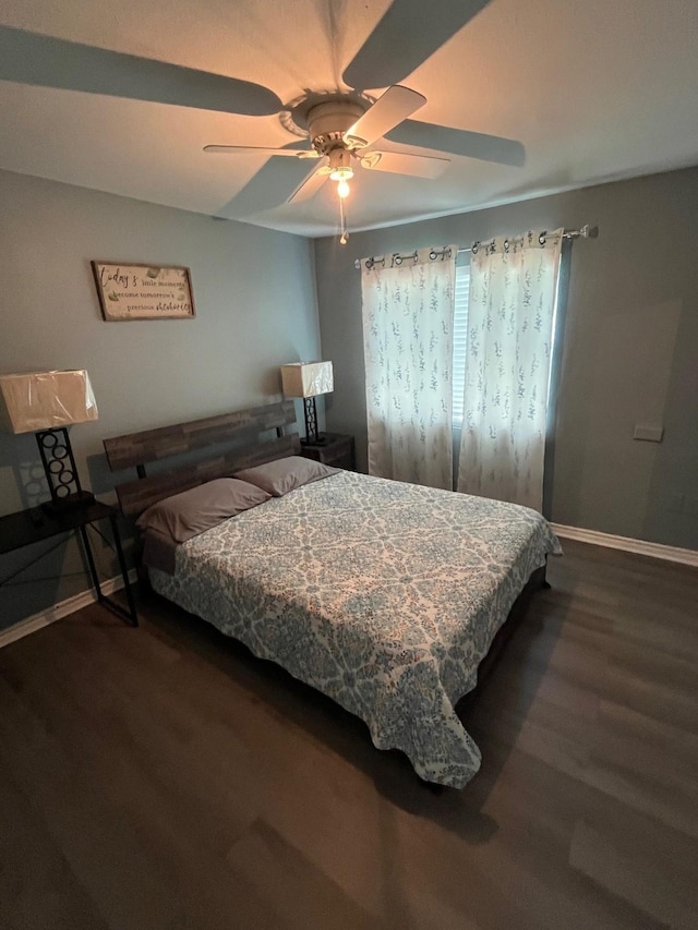 bedroom with baseboards, a ceiling fan, and dark wood-style flooring