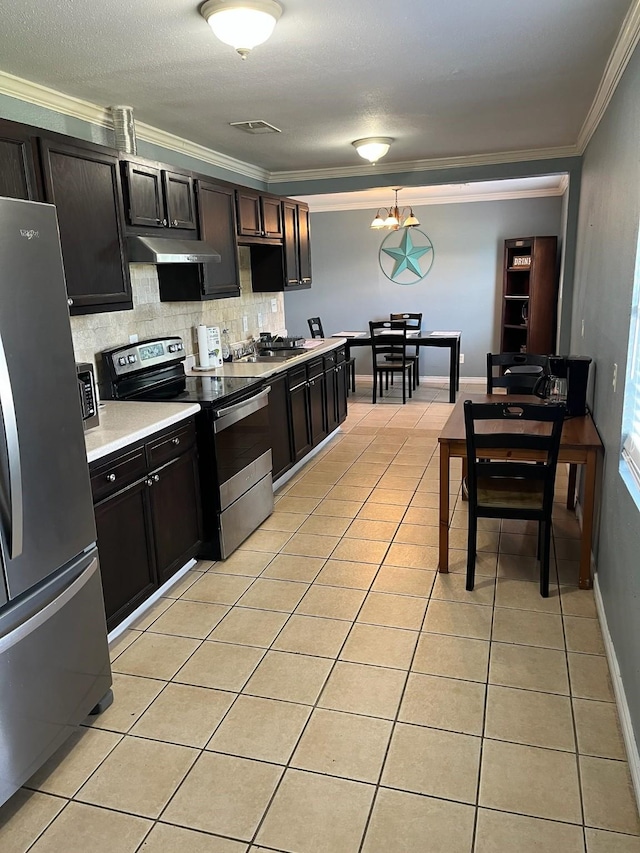 kitchen with light tile patterned floors, crown molding, visible vents, stainless steel appliances, and light countertops