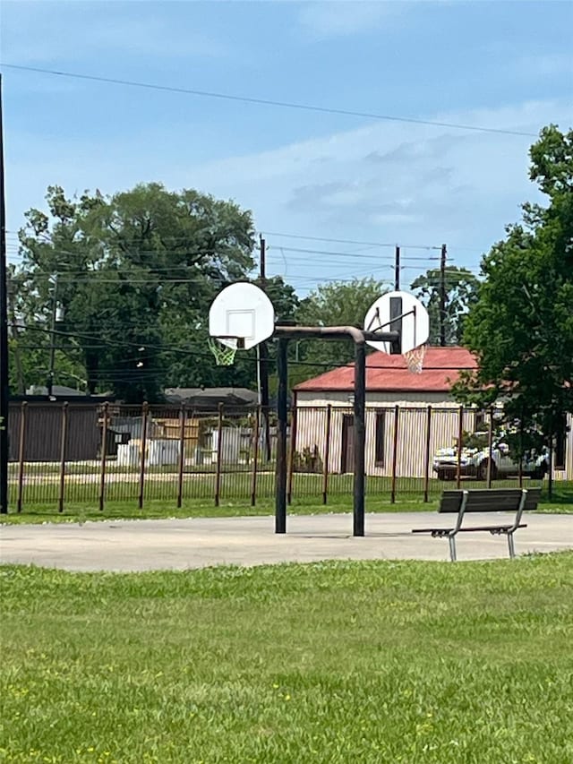 view of sport court with a lawn, fence, and community basketball court