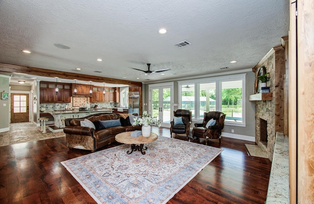 living area featuring baseboards, a wealth of natural light, a ceiling fan, and visible vents