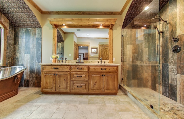 full bath featuring crown molding, a sink, a freestanding tub, and a tile shower