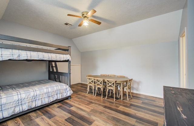 bedroom featuring a textured ceiling, vaulted ceiling, wood finished floors, and visible vents