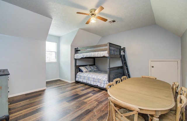 bedroom with ceiling fan, vaulted ceiling, wood finished floors, and visible vents