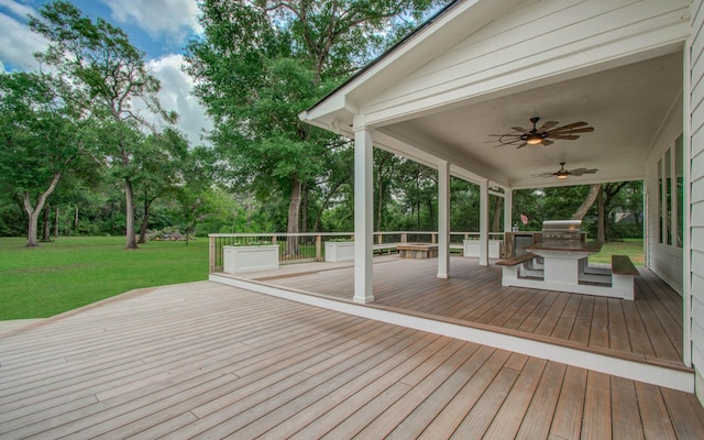 wooden deck featuring ceiling fan, a yard, exterior kitchen, and a grill