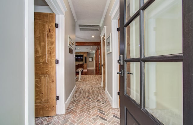 hall with baseboards, visible vents, and brick floor