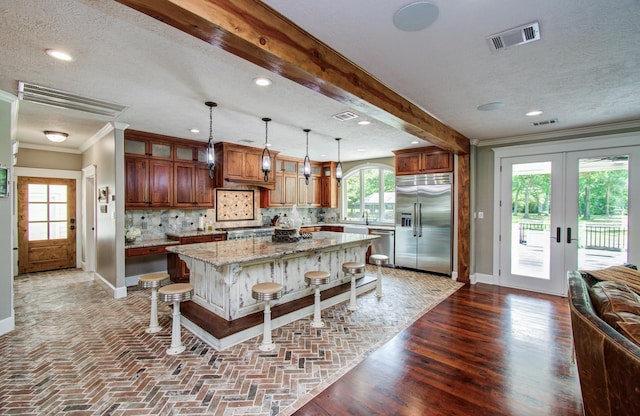 kitchen featuring crown molding, appliances with stainless steel finishes, baseboards, and visible vents