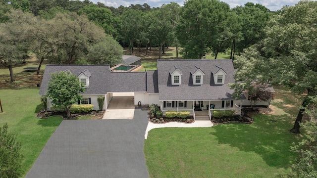 cape cod house featuring a front lawn, aphalt driveway, roof with shingles, and covered porch