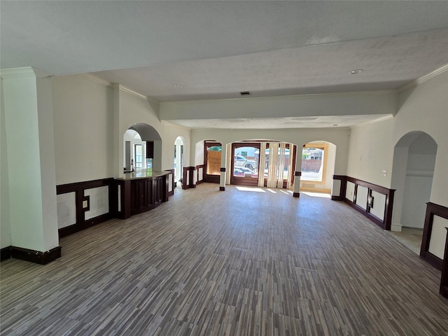 unfurnished living room with crown molding, baseboards, visible vents, and wood finished floors