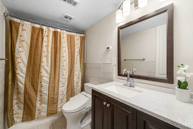 full bath featuring toilet, tile walls, visible vents, and vanity