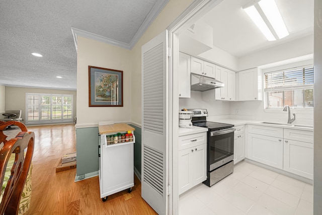 kitchen featuring under cabinet range hood, light countertops, a sink, white cabinetry, and stainless steel range with electric stovetop