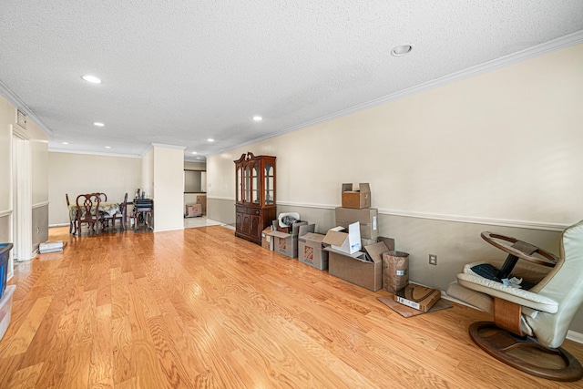 misc room with ornamental molding, a textured ceiling, and light wood-type flooring