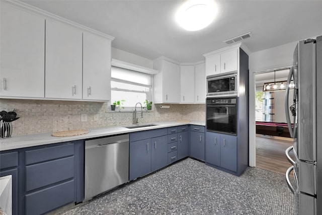 kitchen featuring visible vents, blue cabinets, a sink, backsplash, and stainless steel appliances