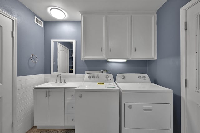 laundry area with a sink, cabinet space, independent washer and dryer, and visible vents