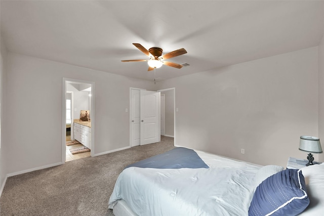 carpeted bedroom featuring visible vents, baseboards, ensuite bathroom, and ceiling fan