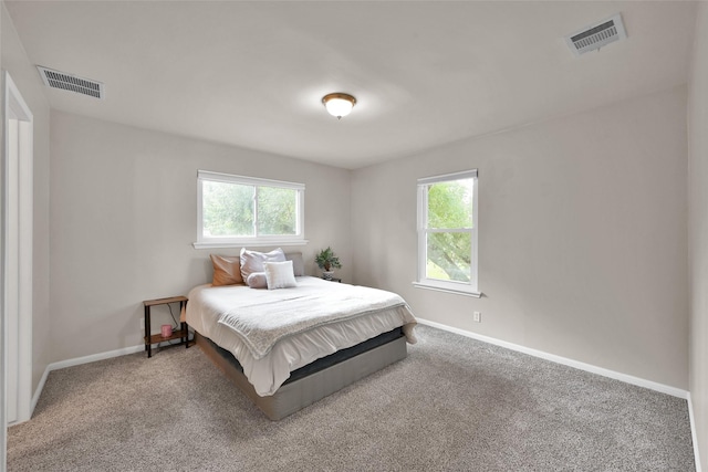 carpeted bedroom featuring baseboards and visible vents