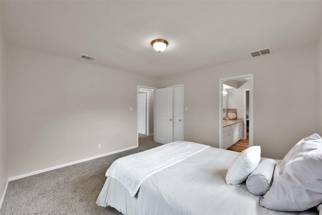 bedroom with visible vents, baseboards, ensuite bathroom, and dark colored carpet