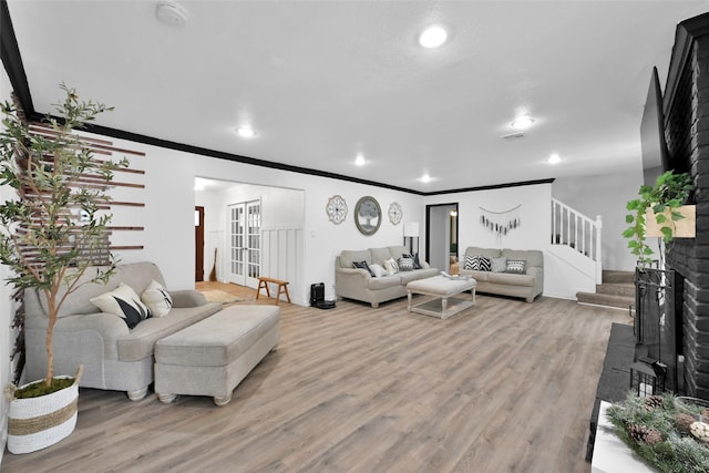 living room featuring stairs, recessed lighting, ornamental molding, and light wood finished floors