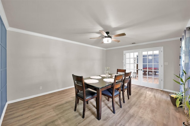 dining space featuring light wood-style floors, baseboards, a ceiling fan, and french doors
