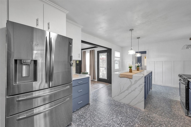 kitchen with light stone countertops, a wainscoted wall, stainless steel appliances, white cabinetry, and pendant lighting