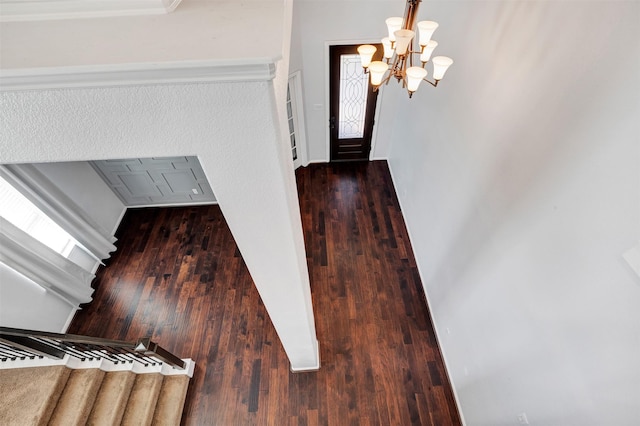 stairway with a chandelier and wood finished floors