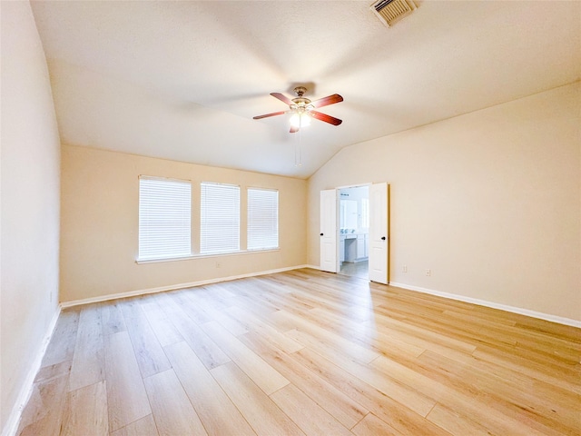 unfurnished room featuring visible vents, light wood-style floors, baseboards, vaulted ceiling, and a ceiling fan
