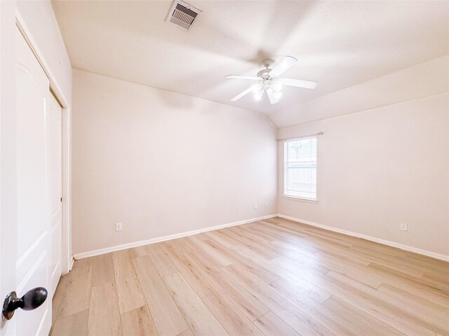 empty room with light wood-style floors, a ceiling fan, visible vents, and baseboards
