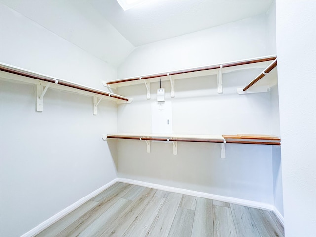 spacious closet featuring lofted ceiling and light wood finished floors