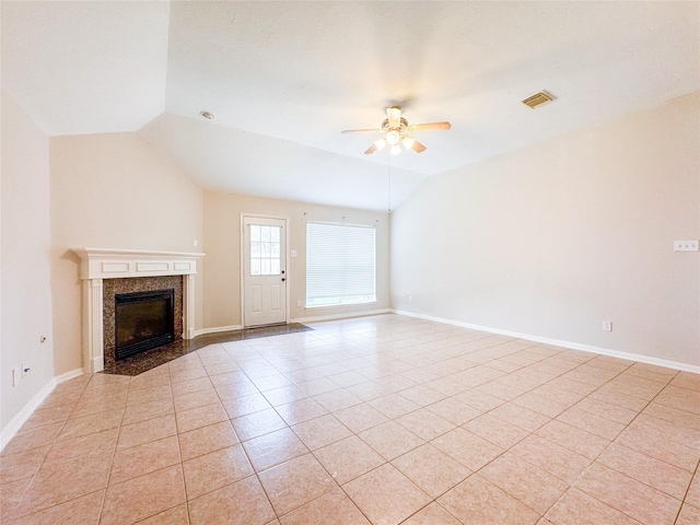 unfurnished living room featuring lofted ceiling, light tile patterned floors, visible vents, a fireplace, and a ceiling fan