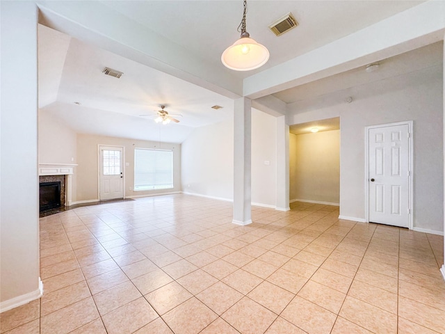 unfurnished living room with light tile patterned floors, visible vents, ceiling fan, and a high end fireplace
