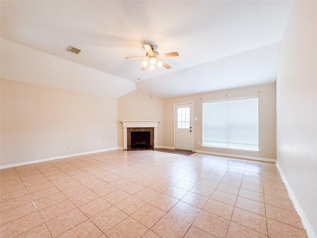 unfurnished living room with a fireplace, light tile patterned floors, ceiling fan, and baseboards