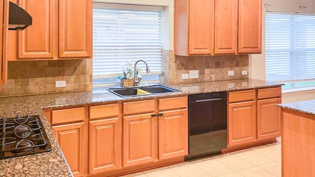 kitchen featuring black appliances, light stone countertops, a sink, and under cabinet range hood