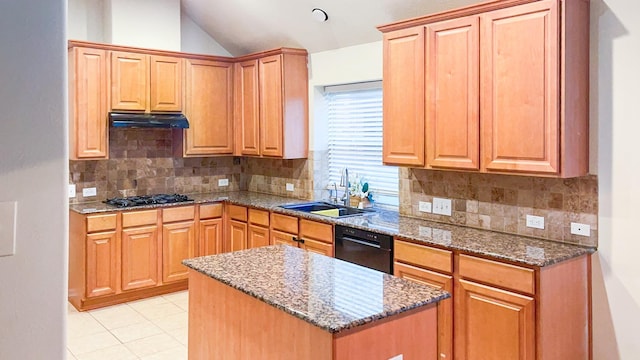 kitchen featuring under cabinet range hood, black dishwasher, stone counters, gas stovetop, and a sink