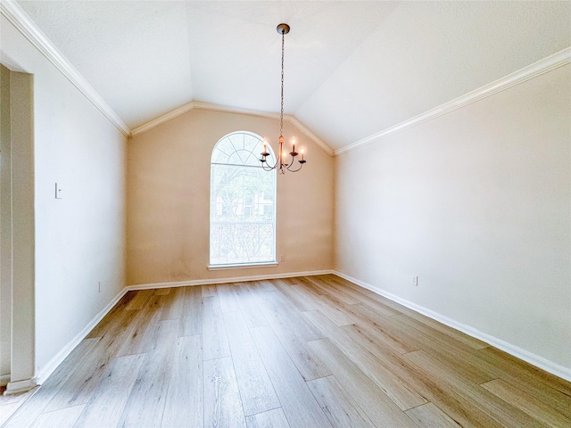 spare room with an inviting chandelier, vaulted ceiling, wood finished floors, and baseboards