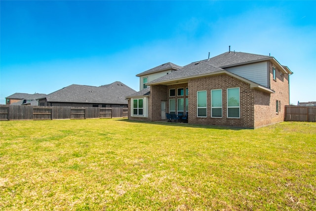 11823 Champions Forest Dr, Dayton, TX 77535 - rear view of house featuring brick siding, roof with shingles, a fenced backyard, and a lawn