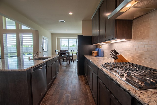 11823 Champions Forest Dr, Dayton, TX 77535 - kitchen featuring appliances with stainless steel finishes, light stone counters, dark wood finished floors, and under cabinet range hood