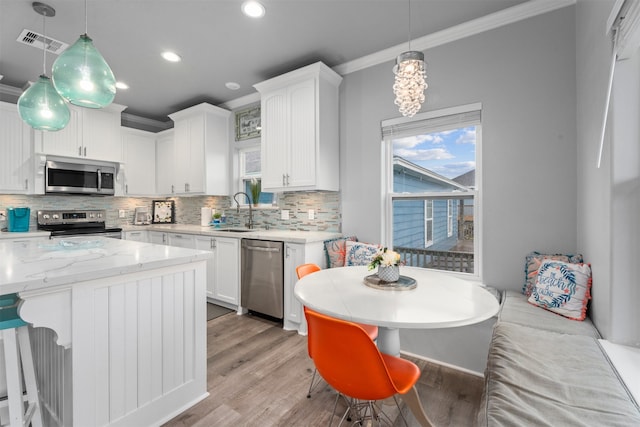 886 Sandollar, Crystal Beach, TX 77650 - kitchen featuring crown molding, visible vents, appliances with stainless steel finishes, and tasteful backsplash