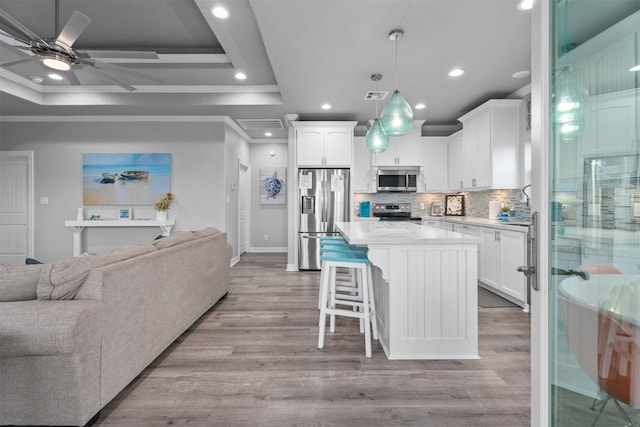 886 Sandollar, Crystal Beach, TX 77650 - kitchen with white cabinets, appliances with stainless steel finishes, a kitchen island, open floor plan, and ornamental molding