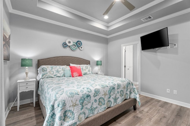 886 Sandollar, Crystal Beach, TX 77650 - bedroom featuring baseboards, visible vents, a raised ceiling, and wood finished floors