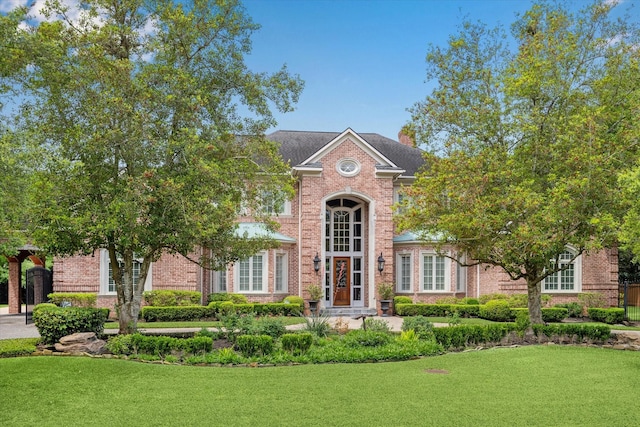 2 Wexford Ct, Piney Point Village, TX 77024 - colonial-style house featuring brick siding, a front yard, and a chimney