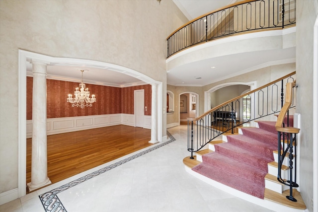 2 Wexford Ct, Piney Point Village, TX 77024 - entrance foyer featuring arched walkways, ornate columns, a chandelier, a high ceiling, and ornamental molding