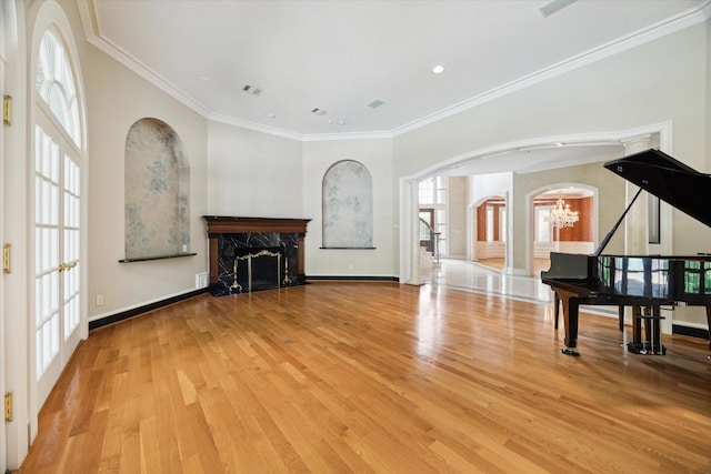 2 Wexford Ct, Piney Point Village, TX 77024 - unfurnished living room with a chandelier, arched walkways, a premium fireplace, wood finished floors, and ornamental molding