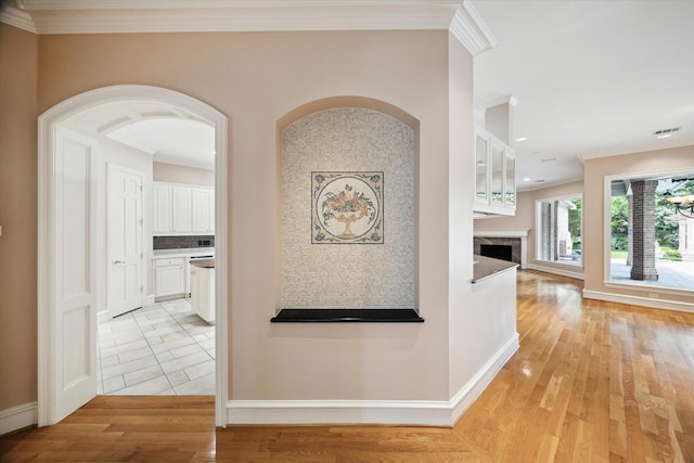 2 Wexford Ct, Piney Point Village, TX 77024 - corridor with ornamental molding, light wood-style flooring, baseboards, and arched walkways