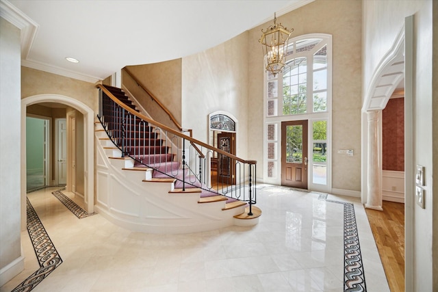 2 Wexford Ct, Piney Point Village, TX 77024 - foyer entrance featuring arched walkways, ornamental molding, inlaid floor details, a chandelier, and stairs