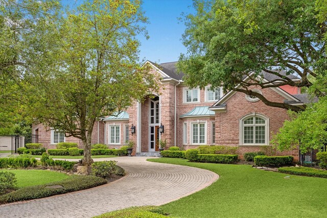 2 Wexford Ct, Piney Point Village, TX 77024 - view of front of home with curved driveway, a front lawn, brick siding, and a standing seam roof