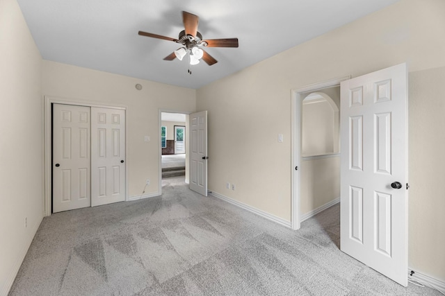 unfurnished bedroom featuring carpet floors, baseboards, a ceiling fan, and a closet