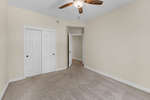 unfurnished bedroom featuring a ceiling fan, baseboards, carpet, and a closet