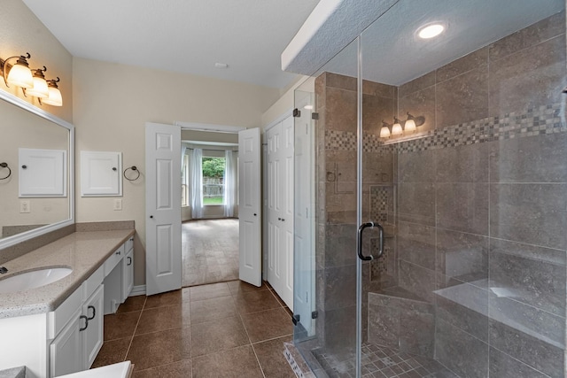 full bath with vanity, tile patterned floors, recessed lighting, baseboards, and a stall shower