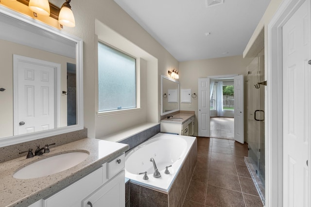 bathroom featuring a jetted tub, two vanities, a sink, and a stall shower