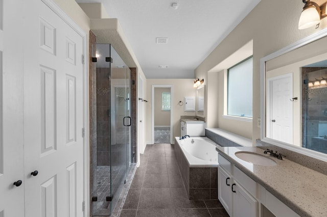 bathroom featuring tile patterned flooring, a bath, two vanities, a shower stall, and a sink